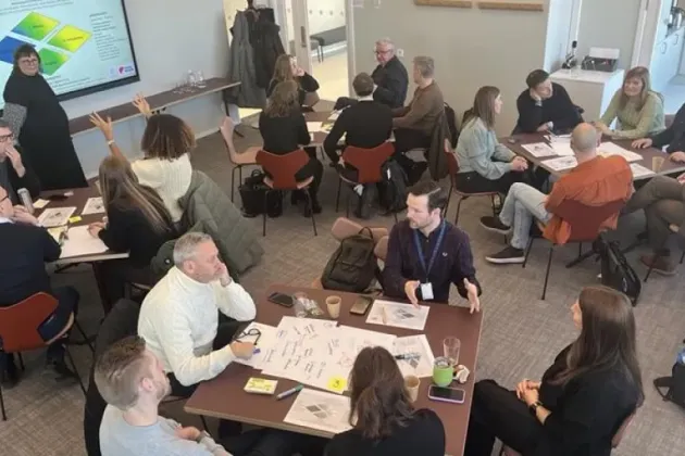 A room full of people in small discussion groups.